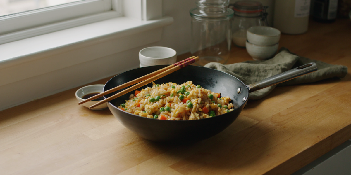 Egg fried rice with peas and carrots in a wok