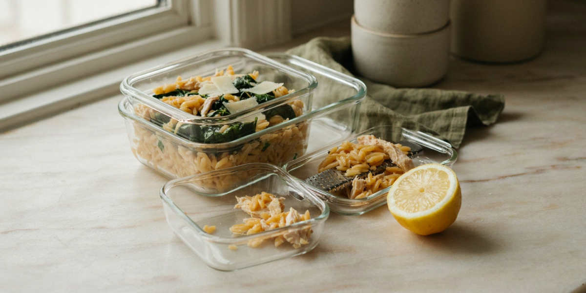 Lemony chicken orzo with spinach and parmesan in a glass container