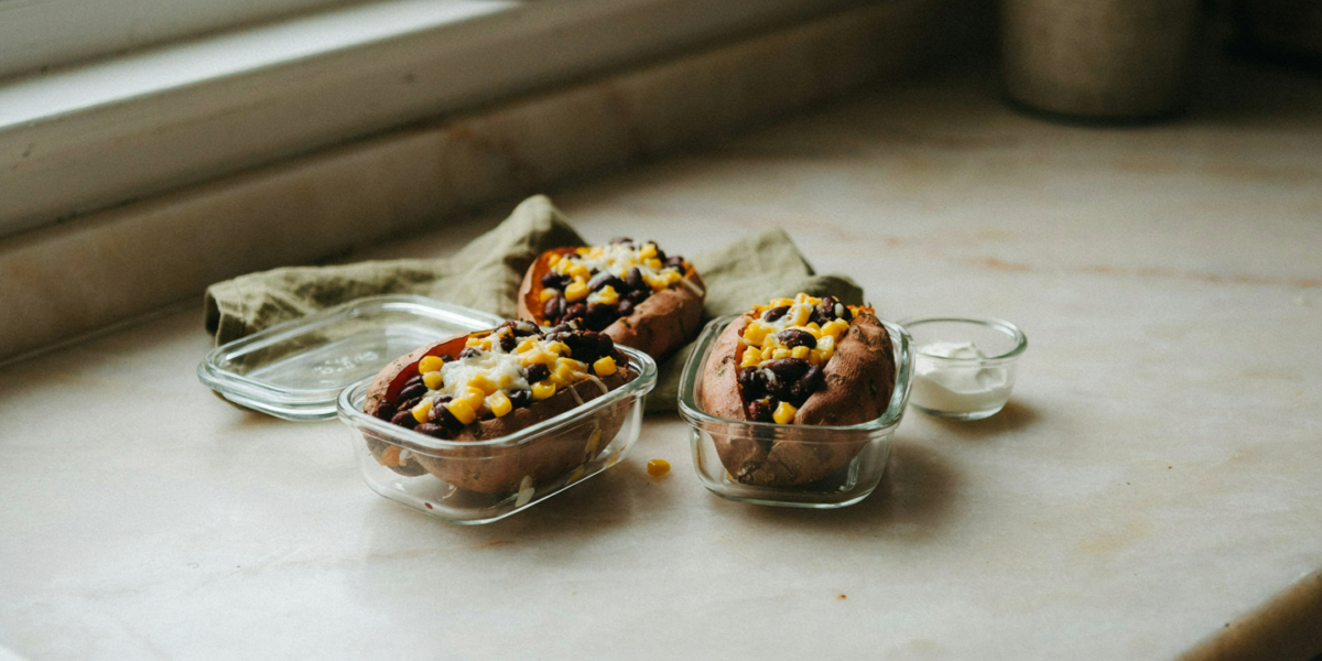 A baked sweet potato split and stuffed with black beans, corn and cheese